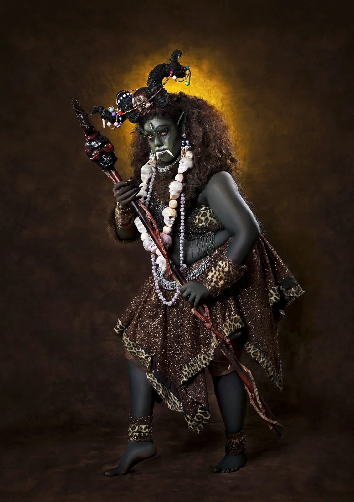 Conceptual fine art portrait of a model styled as a fierce goddess holding a trident