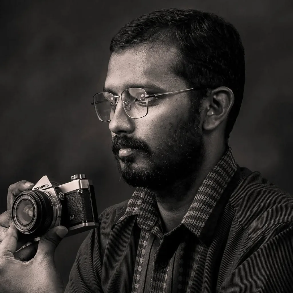 Portrait of photographer Ganabathi Arumugam holding a film camera